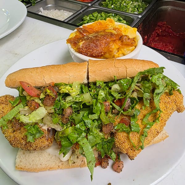 Southern fried catfish po'boy with lettuce and tomato, served with baked mac and cheese.